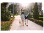 Couple promenant un Golden Retriever dans un parc.