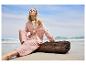 Combinaison pantalon et chemise en gaze de coton rose pâle sur la plage.
