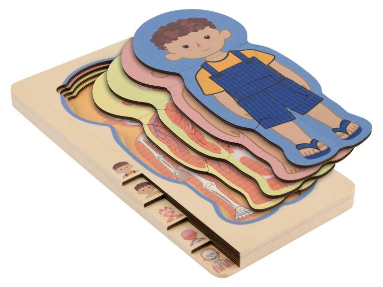 Puzzle en bois superposé du corps humain pour enfants, avec un garçon habillé sur la couche supérieure.