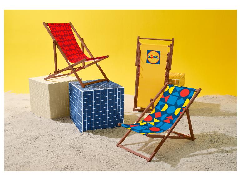Drie strandstoelen met geometrische patronen en één met logo, op zand.