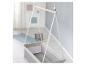 Hangende babywieg in een lichte kamer met een blauw vloerkleed