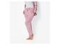 Vrouw in roze velours joggingbroek en bijpassend vest