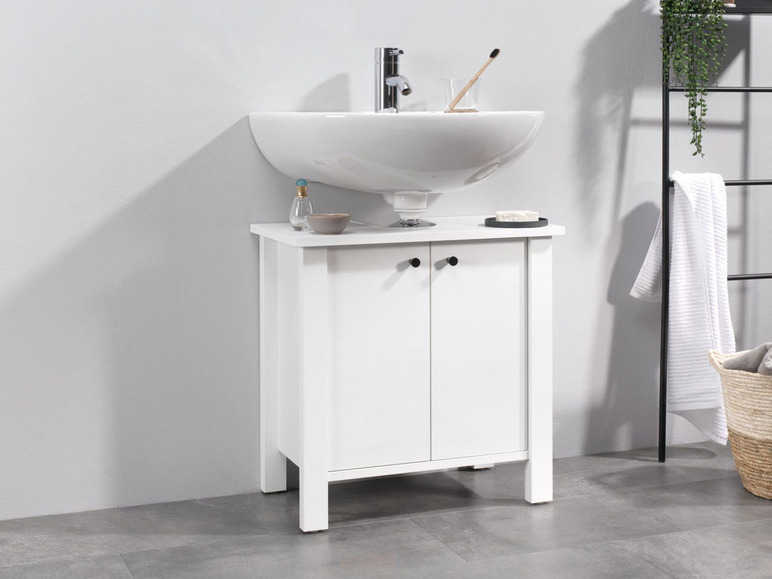 Witte badkamermeubel met wastafel en twee deuren.