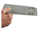 Hand houdt twee metalen platen vast met schroeven.