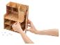 Persoon monteert een houten bureau-organizer.