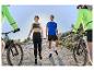 Des personnes portant des vêtements de sport Karrimor font du vélo de montagne par une journée ensoleillée.
