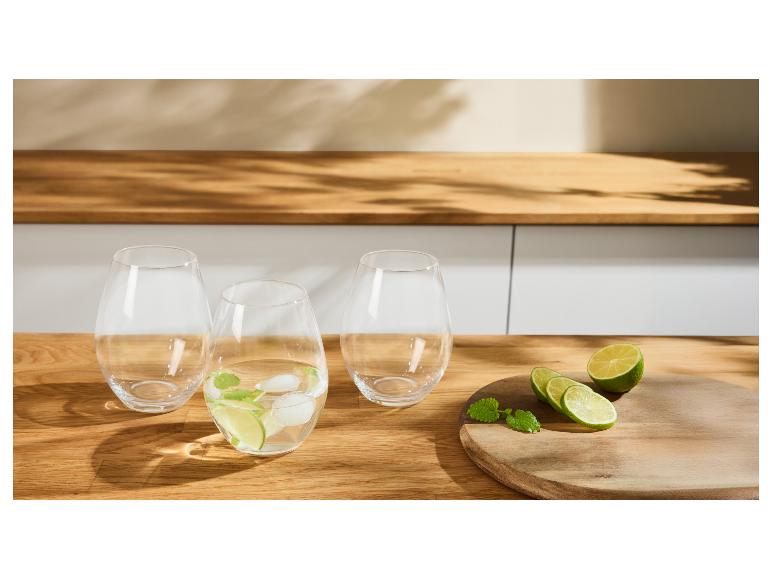 Drie glazen met limoen, munt en ijs op een houten tafel.