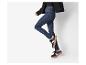 Vrouw in jeans en sneakers.