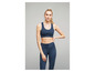 Vrouw in een donkerblauwe sportbeha en leggings.