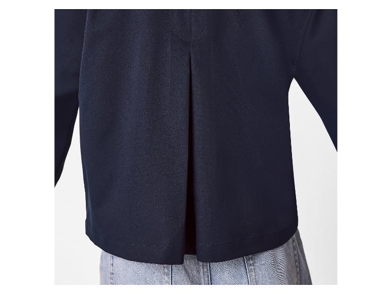 Achteraanzicht van een marineblauwe damesblouse met een plooi, gedragen over lichtblauwe jeans.