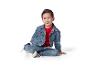 Un enfant souriant portant un jean et une veste en jean.