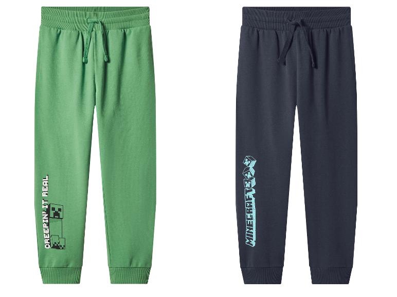 Deux pantalons de survêtement Minecraft pour enfants : un vert avec 'CREEPIN' IT REAL' et un bleu foncé avec le logo Minecraft.