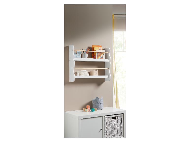 Witte wandplank met boeken en speelgoed in een kinderkamer.