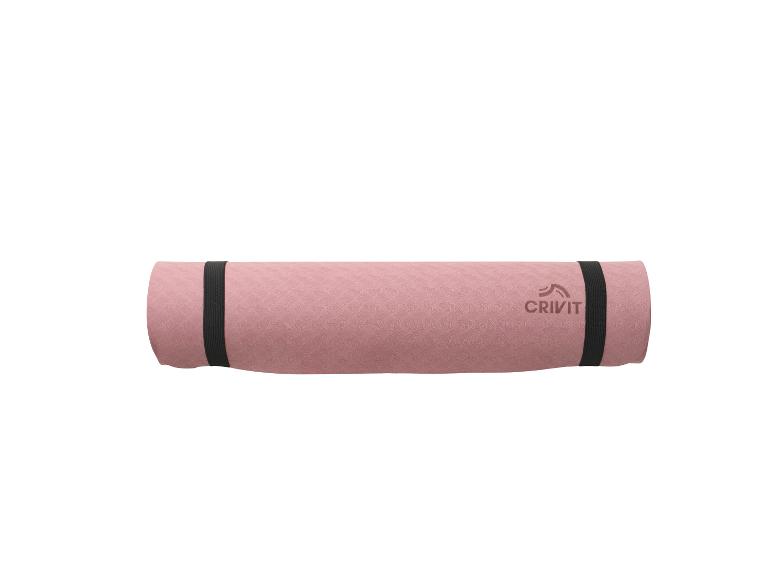 Roze opgerolde Crivit yogamat met zwarte banden