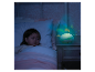 Une petite fille dort près d'une veilleuse projection d'étoiles.