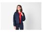Femme en veste bleu marine et pull rouge, souriante et regardant sur le côté.