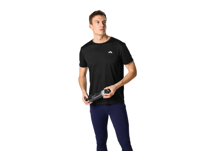 Man in zwart sport T-shirt en marineblauwe legging, met een waterfles.