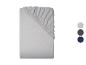 Un drap-housse gris clair, plié, avec trois échantillons de couleurs à droite : gris clair, gris foncé et bleu marine.