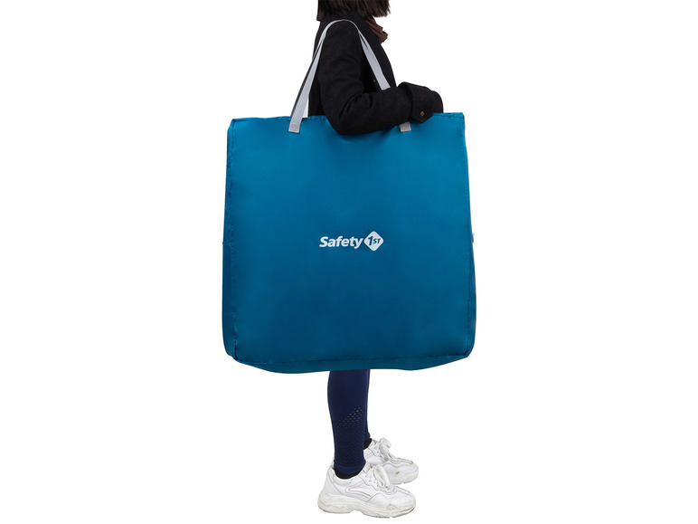 Een vrouw draagt ​​een grote blauwe Safety 1st tas.