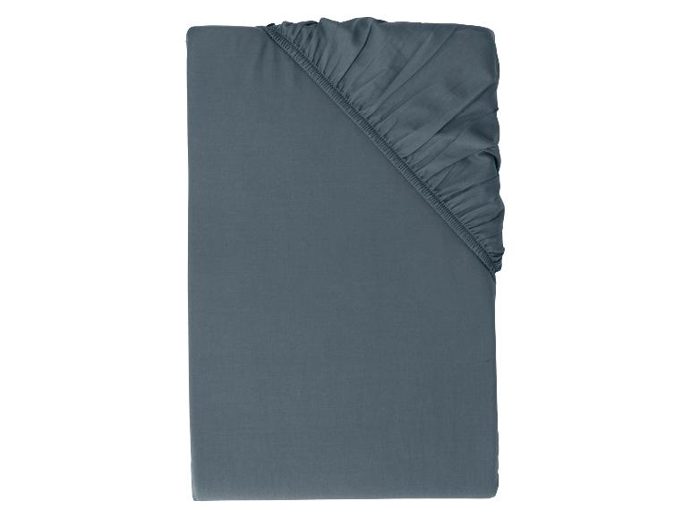 Drap-housse bleu foncé avec coins élastiques, plié sur fond blanc.