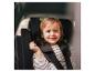 Enfant souriant dans un siège auto pour enfant avec ceintures de sécurité.