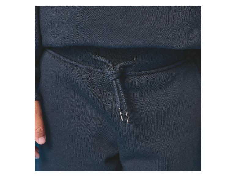 Gros plan d'un pantalon de survêtement bleu marine avec cordon de serrage à la taille.