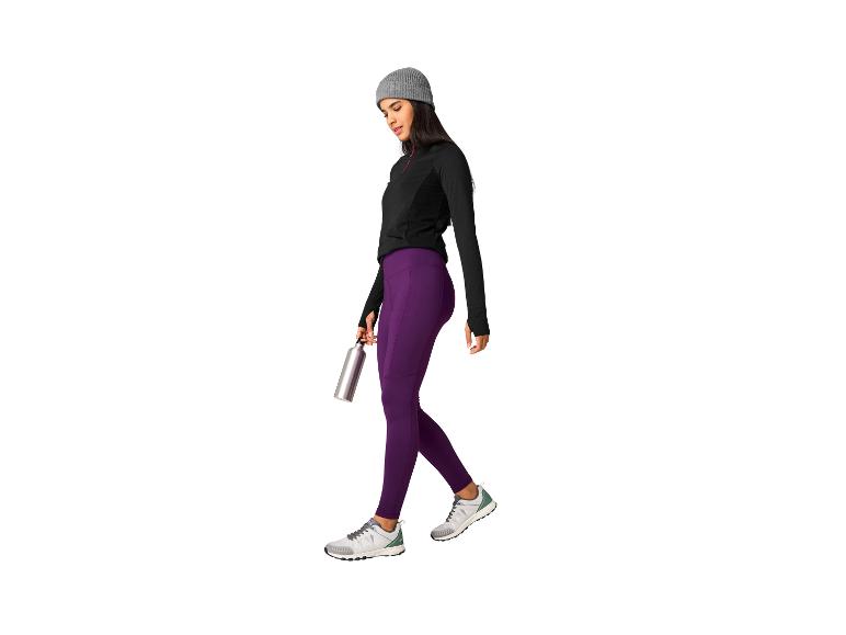 Vrouw in paarse legging en zwarte top, met een waterfles.