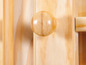 Een houten kast met een ronde knop.