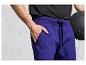 Man met paarse trainingsbroek en een zwarte fitnessbal.