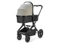 Een zwarte kinderwagen met een beige zonnekap.