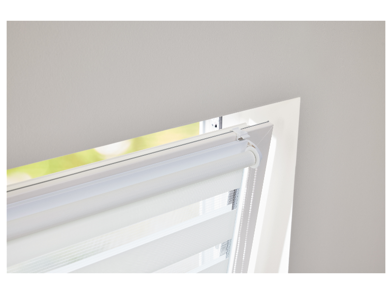 Een wit rollgordijn is in een raam geïnstalleerd.