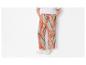 Wijde broek met bloemenprint en witte sneakers.