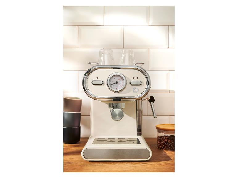 Crèmekleurige espressomachine in retrostijl op een houten aanrecht.