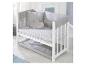 Lit bébé blanc avec literie à carreaux gris et blancs et oreiller en forme de nuage.