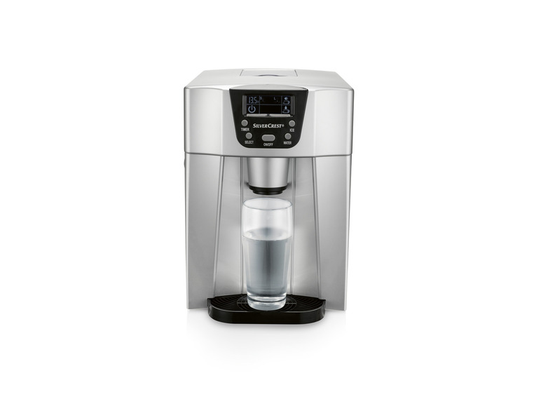 Une machine à glaçons SilverCrest argentée avec un verre d'eau.