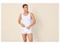 Man in wit hemd en boxershort, lachend en opzij kijkend.