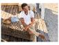 Wit poloshirt, beige broek en loafers op een rotan terras.