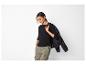 Femme en t-shirt noir à manches longues et pantalon cargo vert, avec veste sur l'épaule.