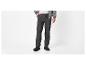 Homme en pantalon cargo gris, t-shirt blanc et sweat à capuche zippé gris.