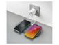Twee smartphones worden opgeladen op een draadloos oplaadstation.