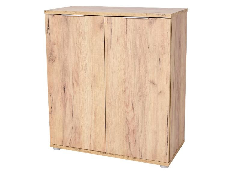 Lichte houten kast met dubbele deuren en zilveren handgrepen.