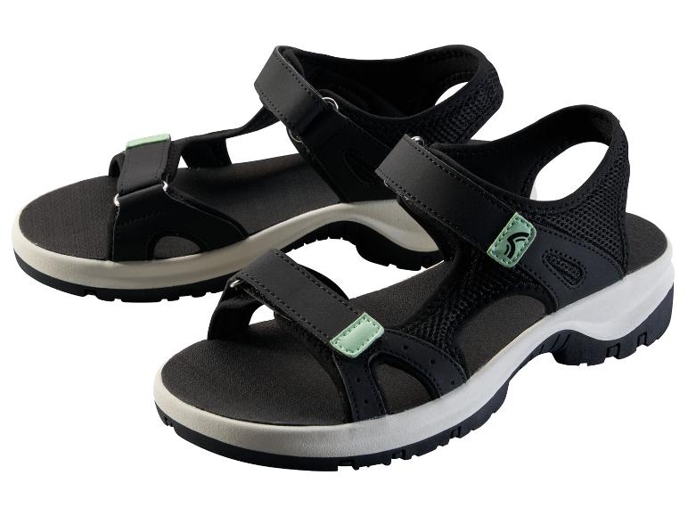 Een paar zwarte sportsandalen met groene accenten op een witte achtergrond.