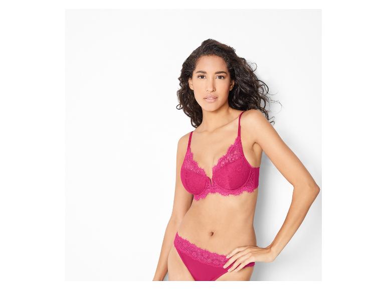 Een vrouw draagt een roze bh en slipje met kant.