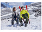 Een man en vrouw met ski-uitrusting in de sneeuw.
