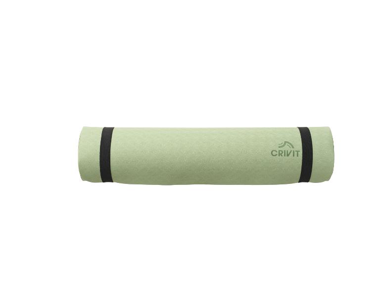 Tapis de yoga Crivit vert clair roulé avec des sangles noires