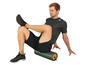 Man met Adidas shirt die op een foam roller zit