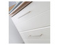 Commode blanche avec trois tiroirs et poignées argentées.
