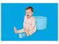 Lachende baby in roze romper en beige panty speelt met bouwblokken.
