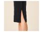 Détail d'une jupe noire avec une fente latérale, montrant la jambe d'une personne.