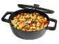 Zwarte pan met deksel gevuld met gnocchi, courgette, champignons en tomaten.